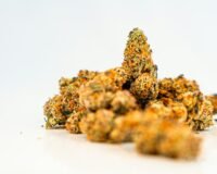 a pile of orange weed sitting on top of a white table